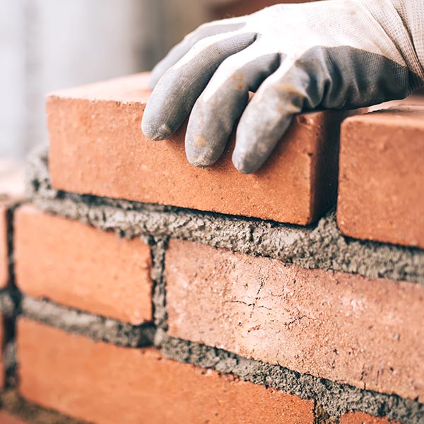 Close up of builder laying bricks