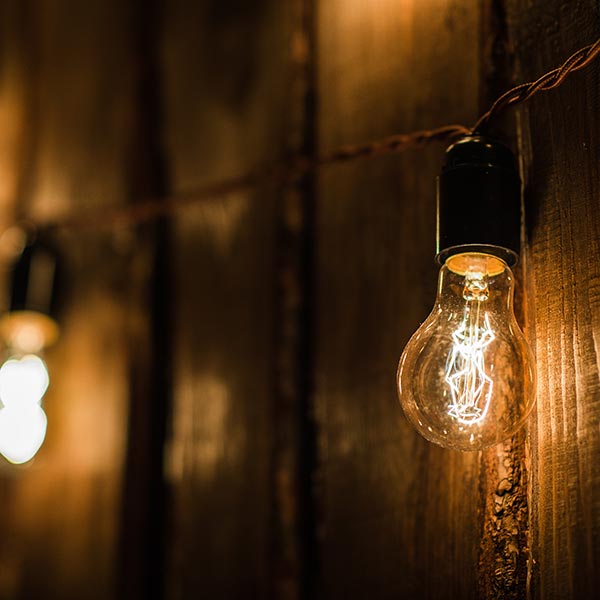 Retro string lamp hanging on wooden fence